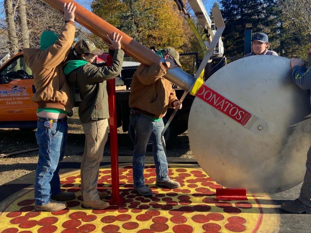 Installing the world's largest pizza cutter statue